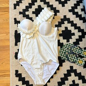 White one-piece swimsuit with ruffle sleeve.